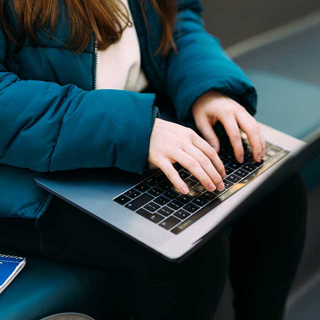 girl typing on laptop