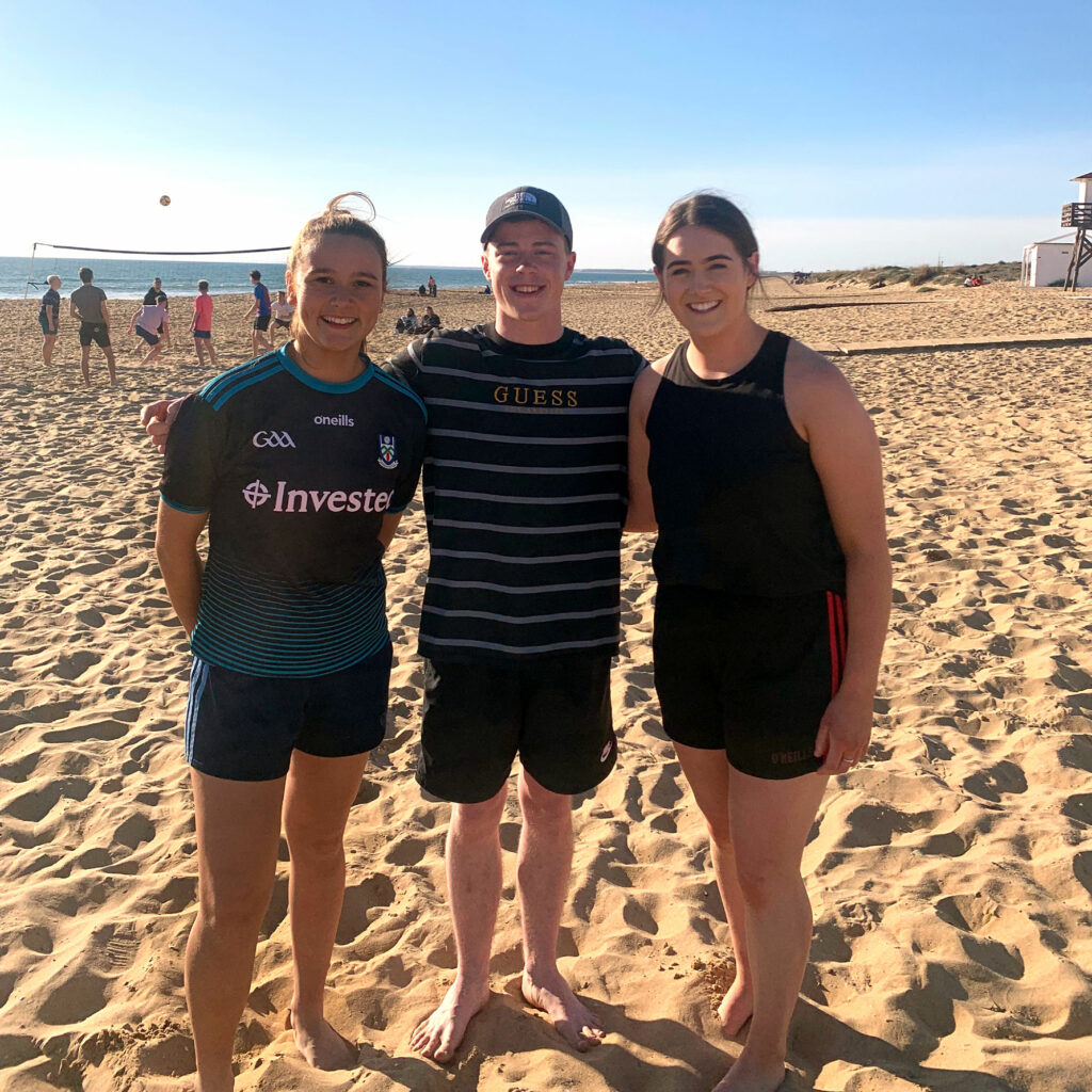 Three students on the beach playing volley ball, part of the exchange and study programme