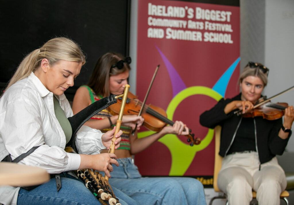 Three student musicians playing Irish music on the stage