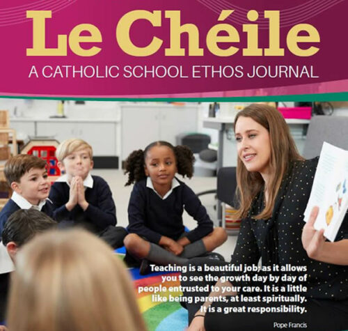 Front cover of Le Chéile Project Journal with a female teacher in a black blouse with white spots sitting on a rainbow mat with a reading book in her hand surrounded by boys and girls in their school uniform of white shirt, navy jumper and grey trousers or skirts also sitting on the mat watching their teacher.