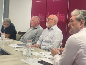 Professor Peter Finn seated behind a table with Professor Gerard McCann and other attendees at the day long educational discussion with school teachers from Gaza.