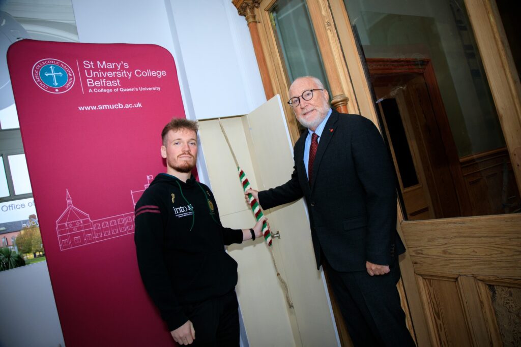 student union president with Professor Peter Finn ringing the chapel bell in the St Marys hall entrance