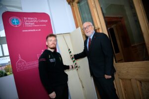 student union president with Professor Peter Finn ringing the chapel bell in the St Marys hall entrance